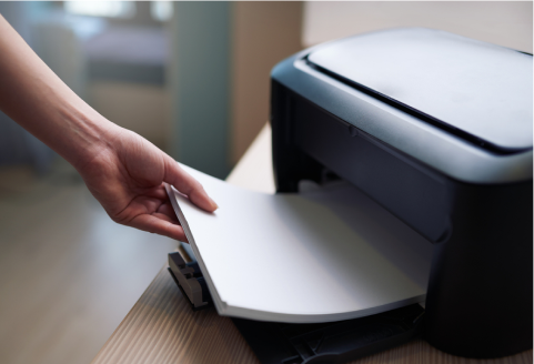 Imagem de uma pessoa colocando um maço de papel sulfite na impressora