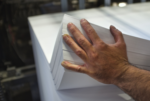 M&atilde;o segurando pap&eacute;is offset